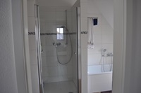 Badezimmer mit Dusche, Badewanne und Sauna